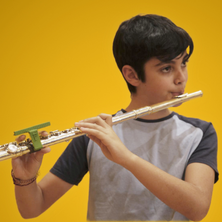 A boy playing the flute with confidence.